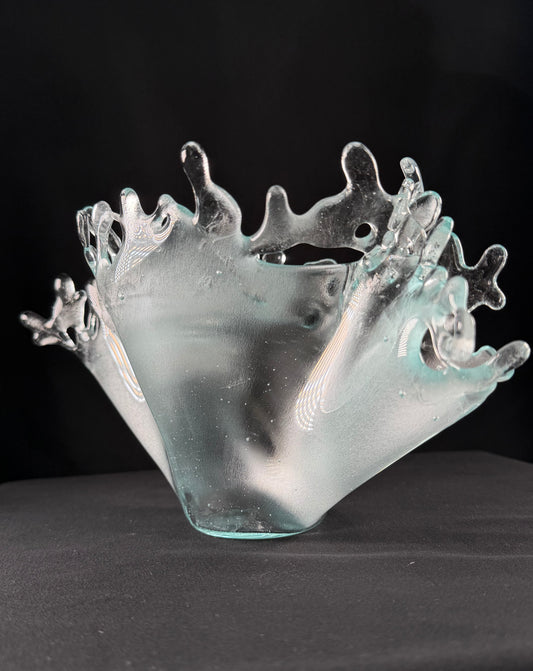 Glass bowl with wave-like design on a black background