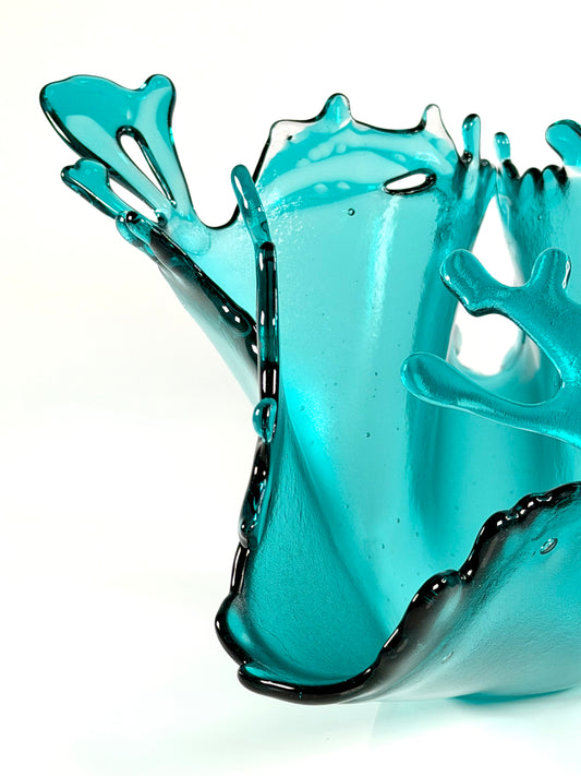 Turquoise glass sculpture on a white background