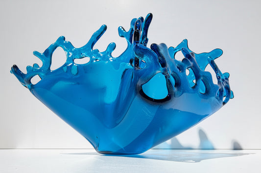 Blue Topaz sculpture depicting water being shot up from a splash on white background