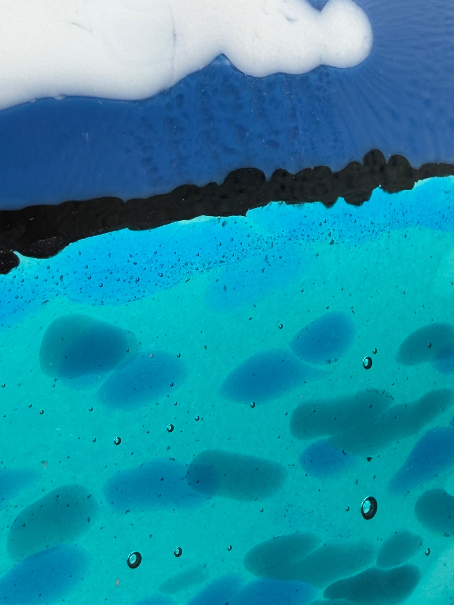Abstract layered artwork with a white textured top section, a dark horizontal band, and a bright turquoise-blue lower section with organic dark blue shapes and small bubble-like highlights.