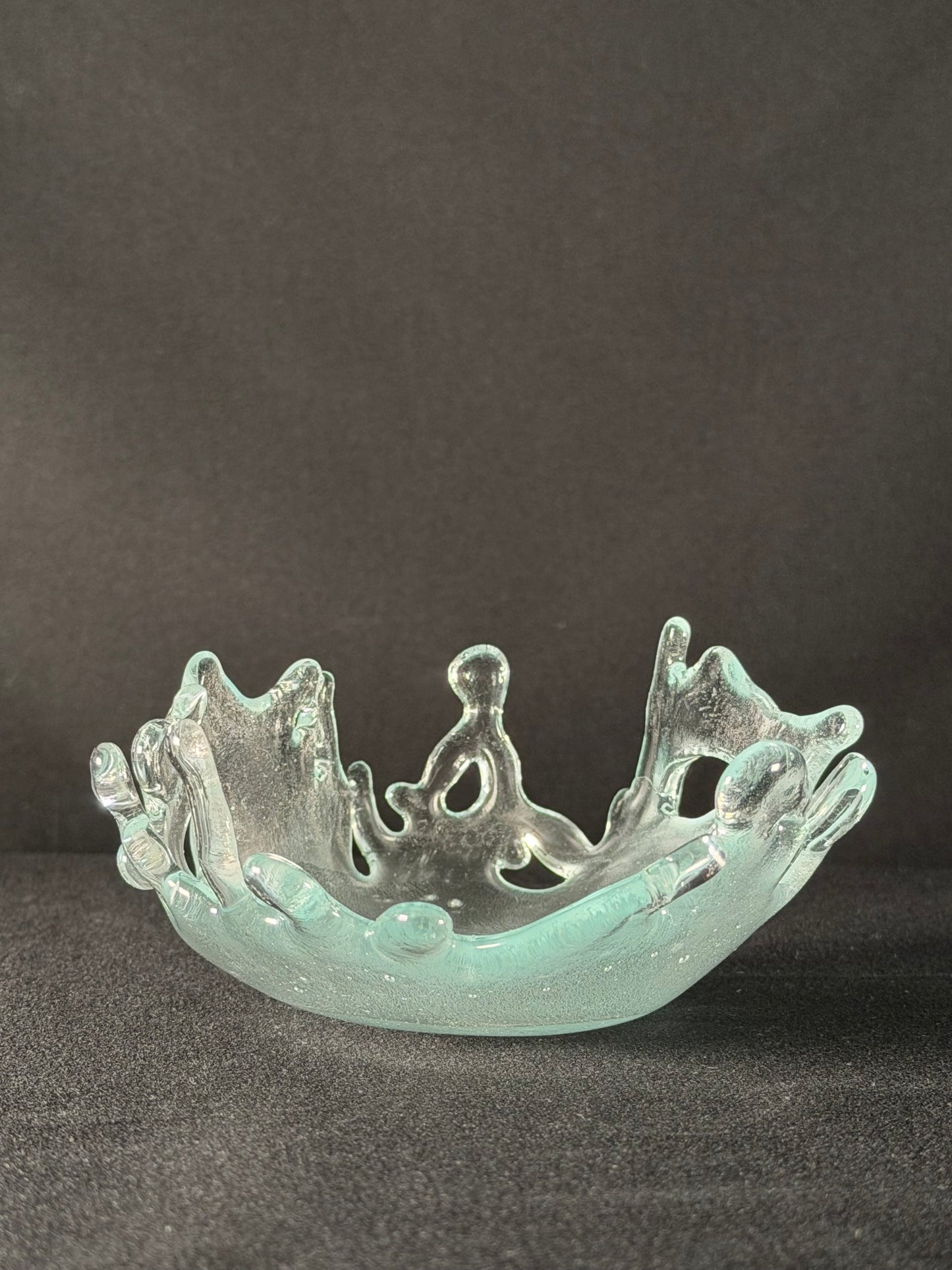 Clear glass object with intricate design on a dark background