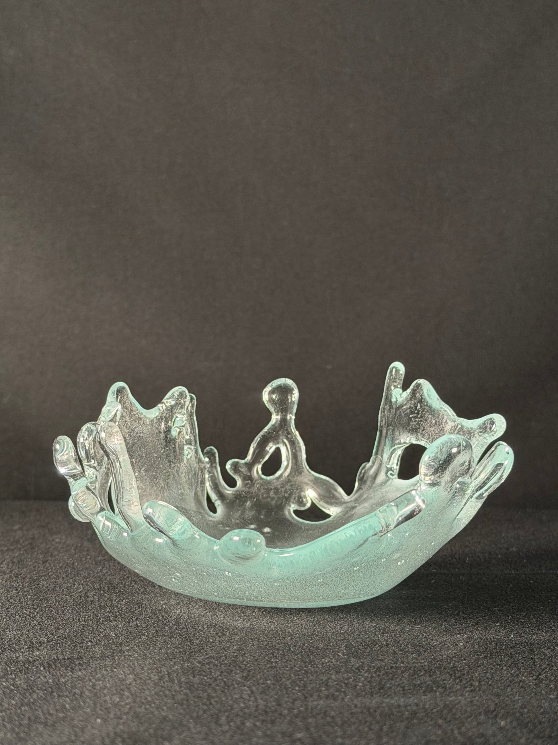 Clear glass object with intricate design on a dark background