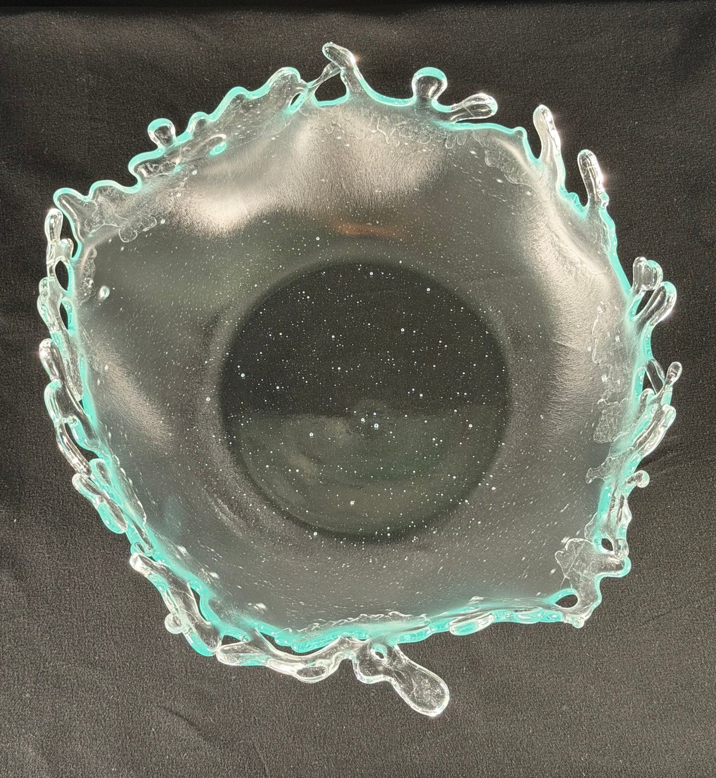 Decorative glass bowl with a textured rim on a black background