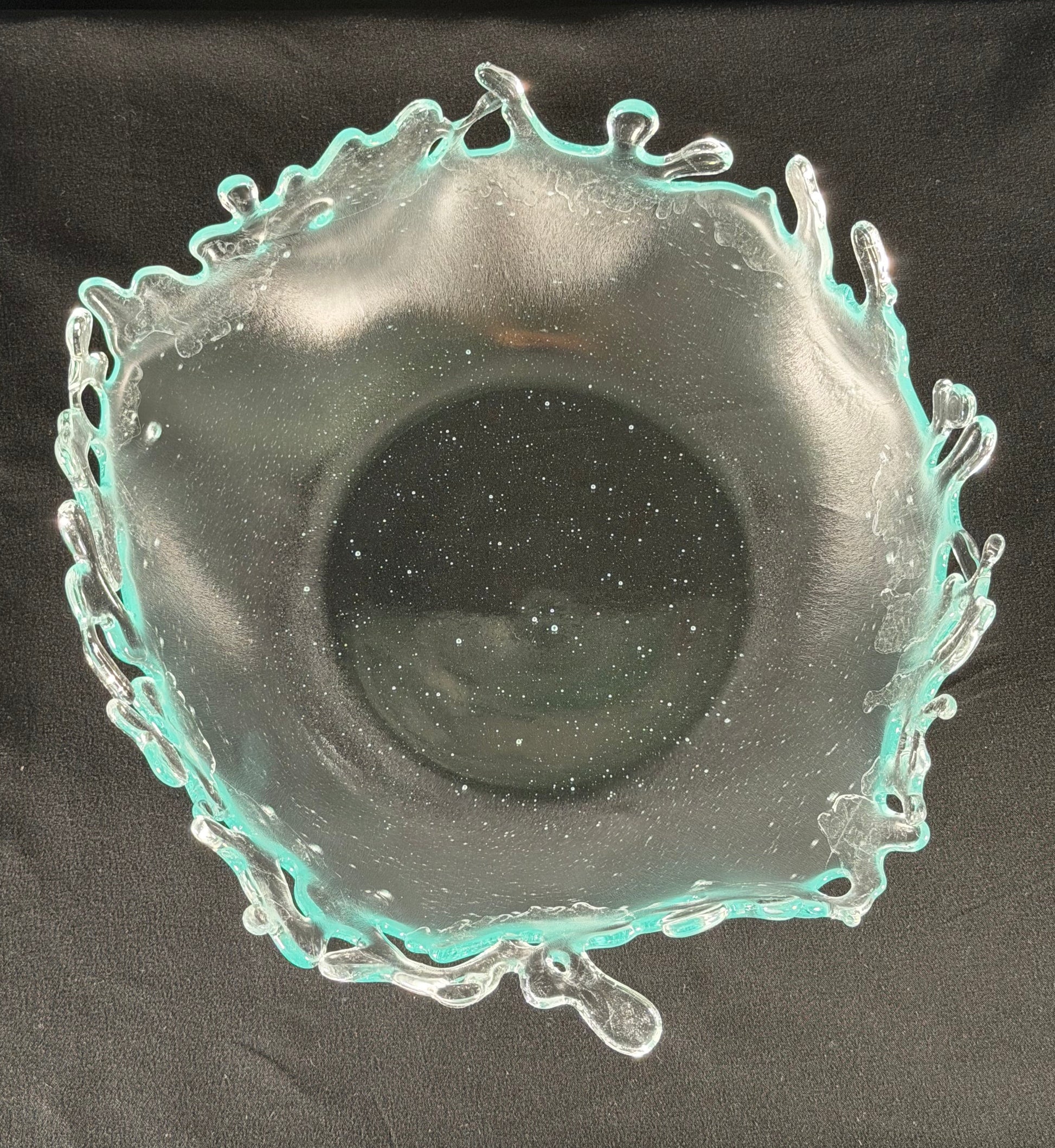 Decorative glass bowl with a textured rim on a black background