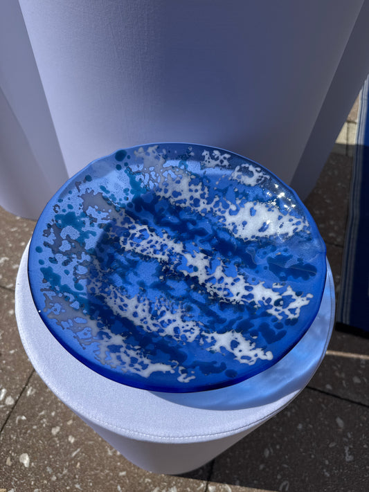 Blue and white bowl with on a white stand outdoors