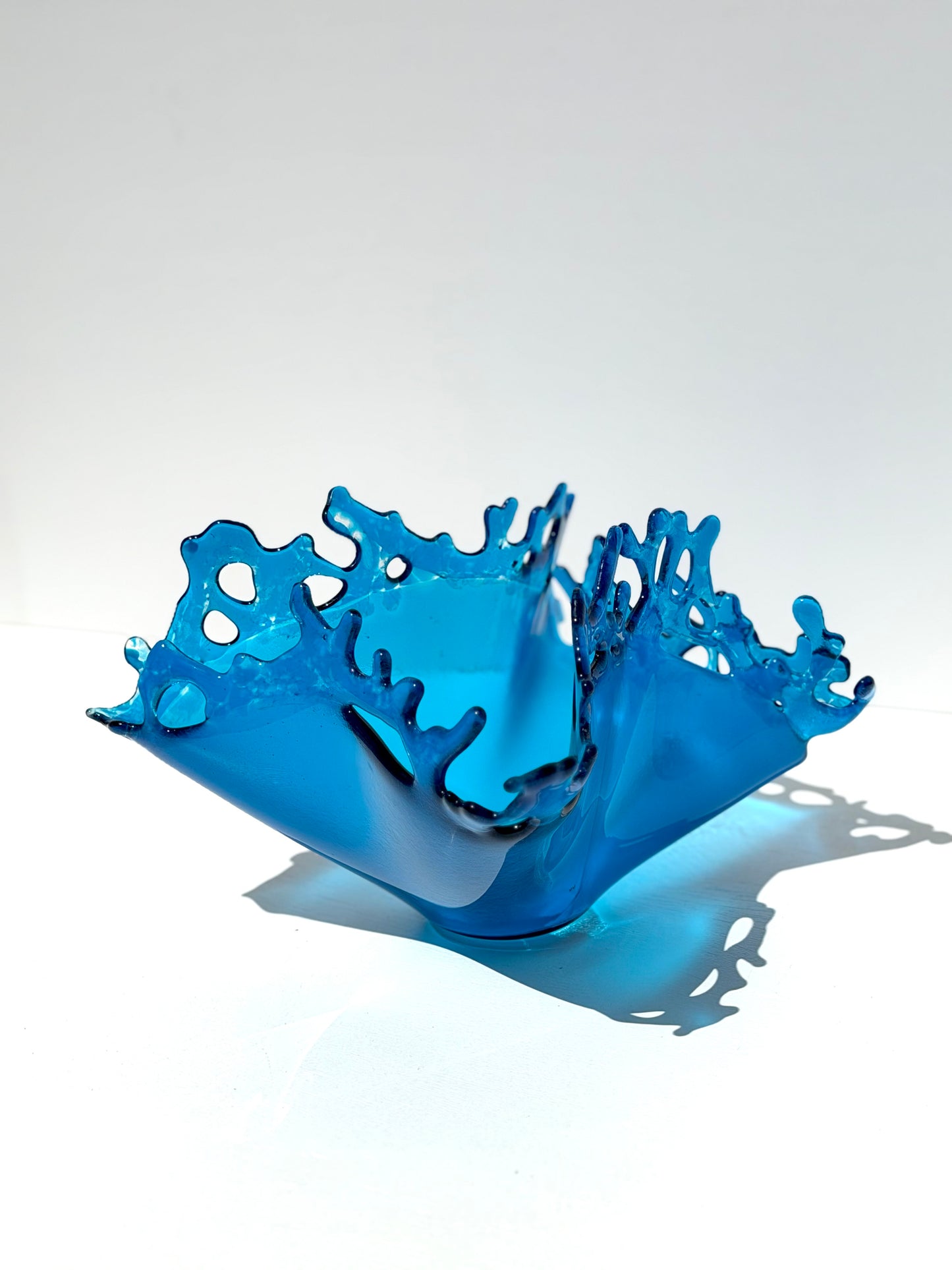 Blue Glass sculpture depicting water splashing upward