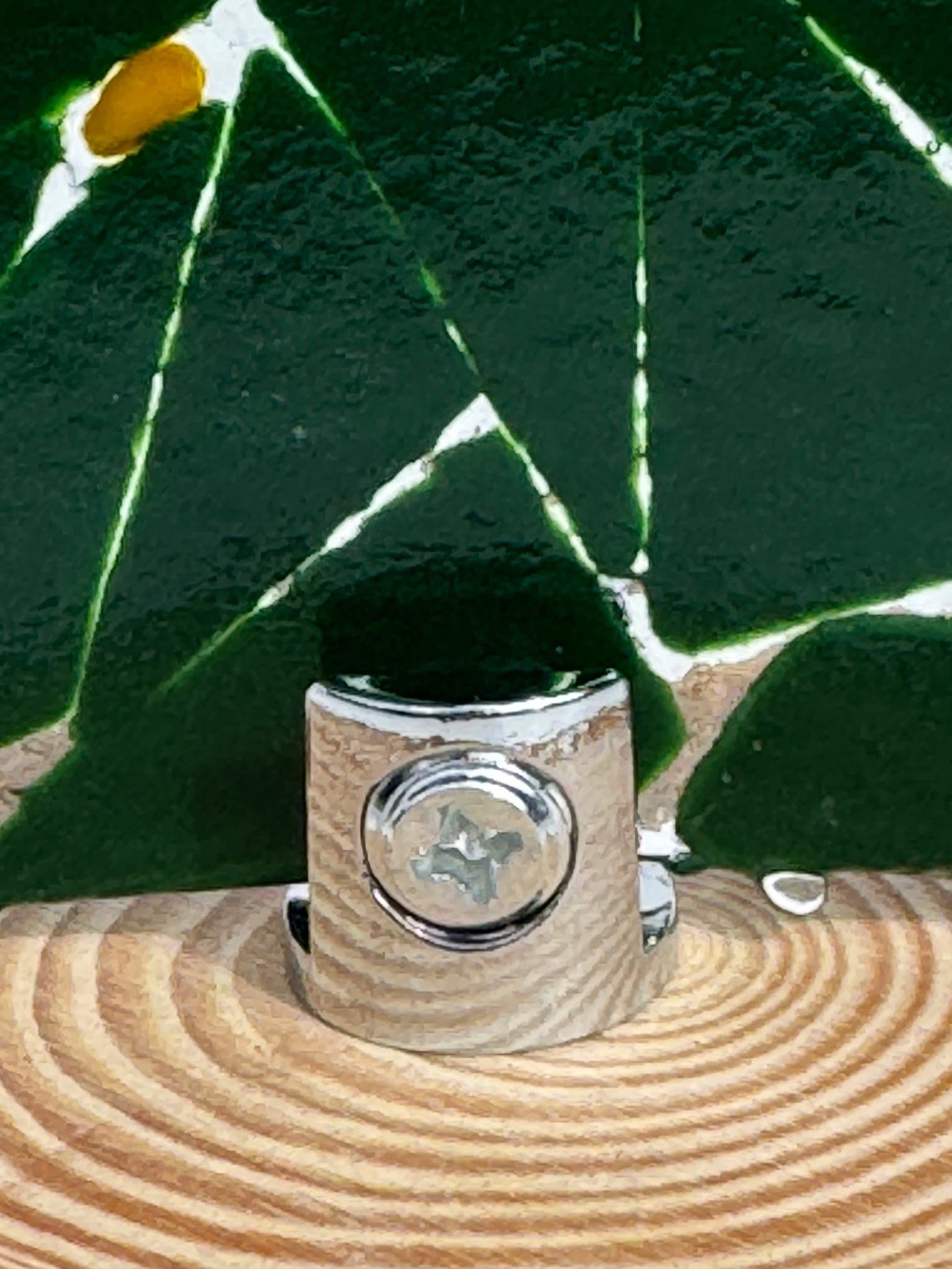 Back of christmas tree shows the chrome finding that secure the tree to the wooden stand. Philips head screw holds the tree to the stand and can be unscrewed to store flat.
