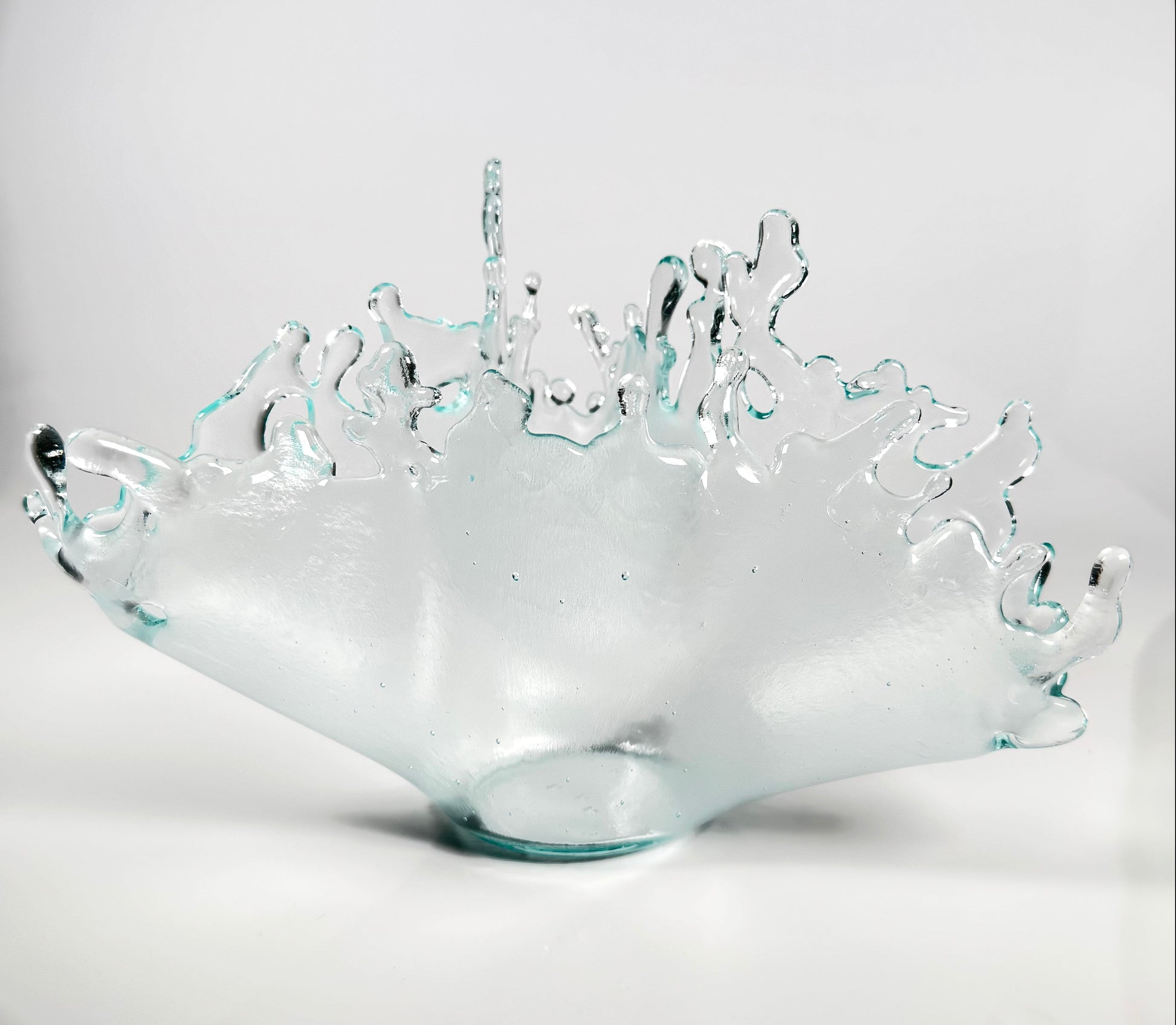 Clear glass bowl with wavy edge design on a white background
